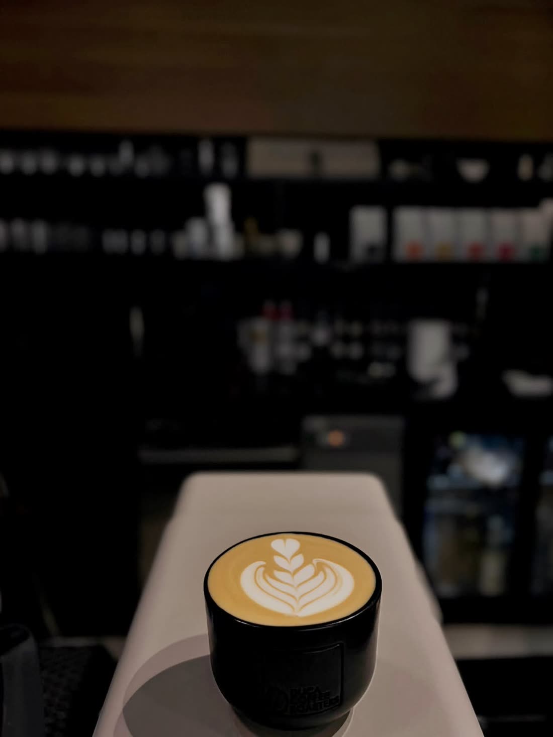 Latte art on the counter with the espresso bar in the background
